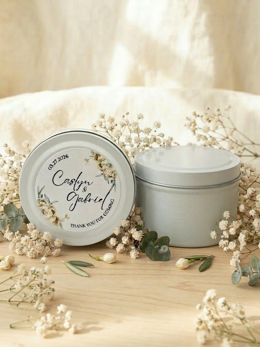 Two white containers with decorative labels on a wooden surface with baby's breath flowers.