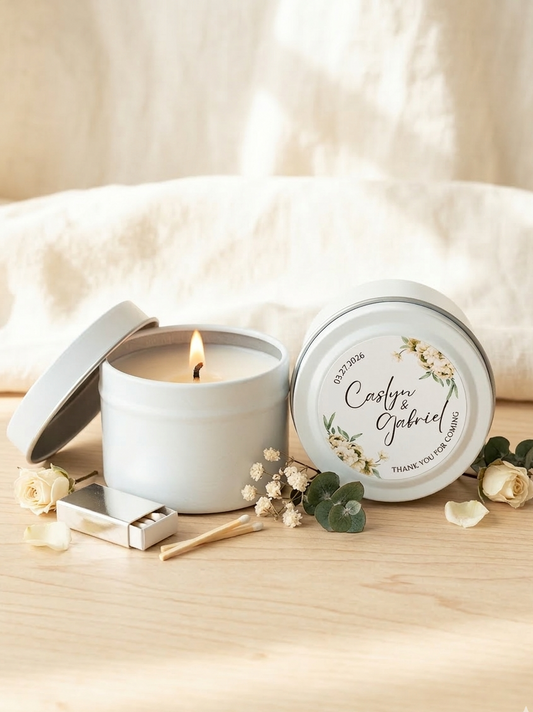 White candle in a tin with a decorative label on a wooden surface